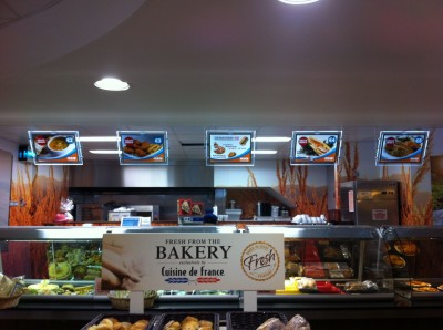 As these angled, illuminated menu boards on suspended rods exemplify, lighting has become easier to integrate into slim signs, thanks to the compact size and minimal heat generation of LEDs.