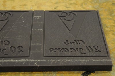 Powdered metal and HDU are mixed and poured into the mould, which is then placed inside a pressure chamber, both to eliminate any air in the liquid and to force the majority of the metal to the face of the sign.