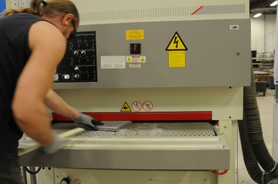 An industrial sander is used to smooth down the rear and side surfaces before painting.