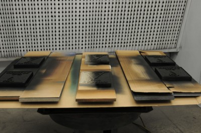 In the paint booth, the signs are given their first coat, which is typically the background colour.