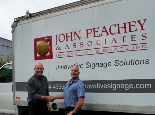Pictured left to right are Dann Konkin, president and CEO of Ampco, and John Peachey, former CEO of Innovative Signage.)]