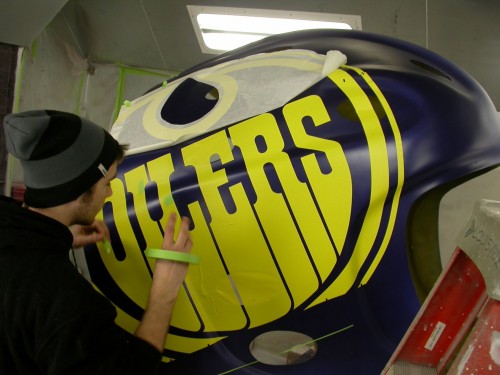 The ‘trans-mask’ is peeled away and any kinks are removed before further application of base paint colours.