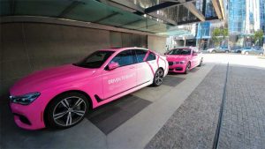 Photo courtesy Multigraphics Magenta and white fence banners and neon vehicle wraps adorned the pavilion’s exterior.. BEAUTY