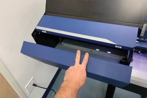 Photo courtesy Roland DGA When prompted, open the left service door of the Roland DG inkjet printer by pulling downward.