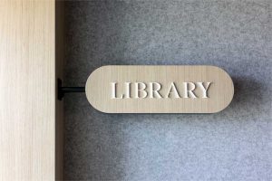 Hanging room signage helps highlight amenity spaces throughout the office.