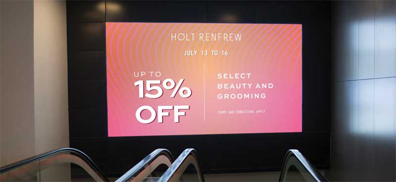 A digital mall billboard advertising the Holts campaign.