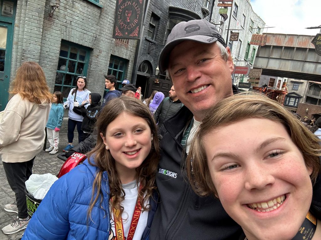 Carl and his daughters smile for a selfie.