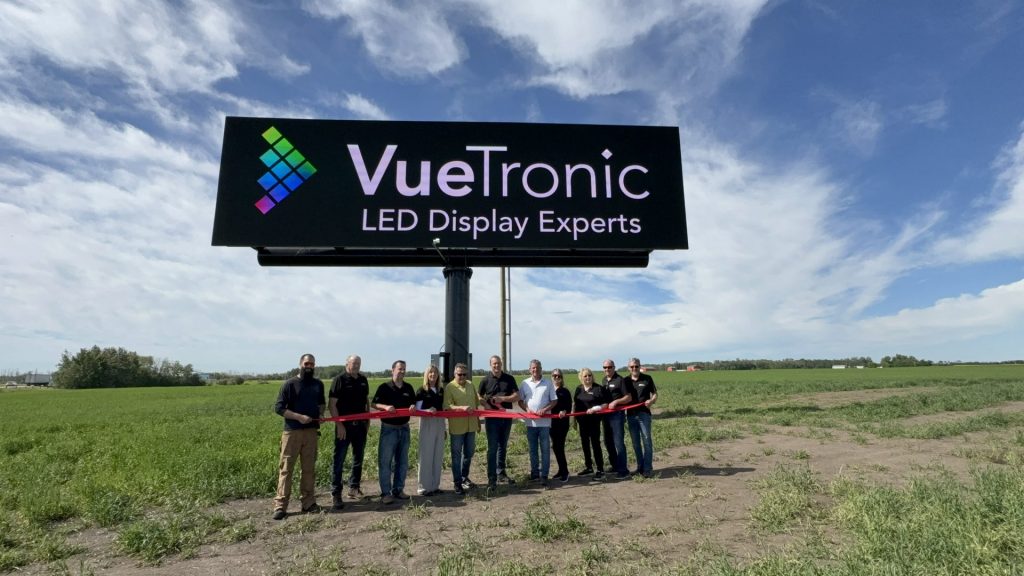 The superboard in display along with the team standing under it.
