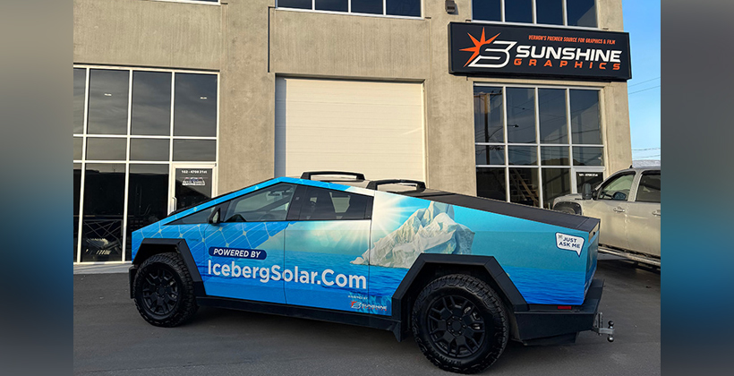A wrapped Cybertruck is parked in front of the Sunshine Graphics building/office.