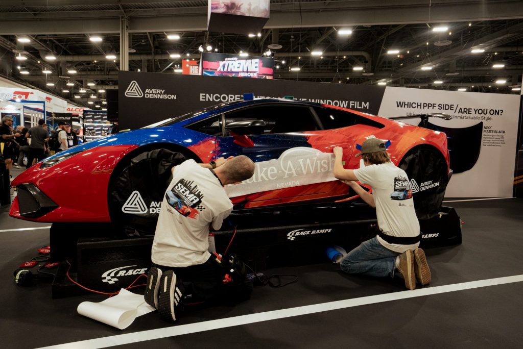 The two young men wrapping the car. 