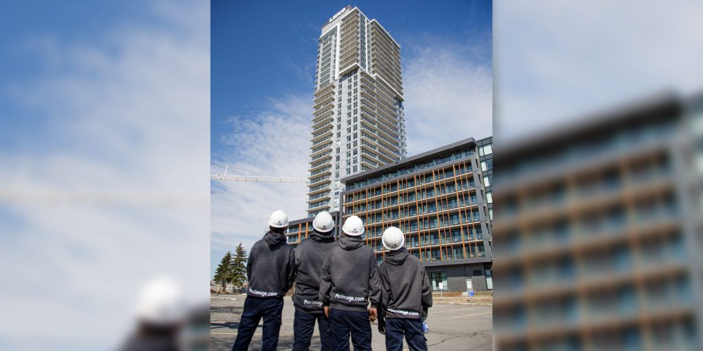 The team with their backs facing the camera looking at the sign from the ground level. 