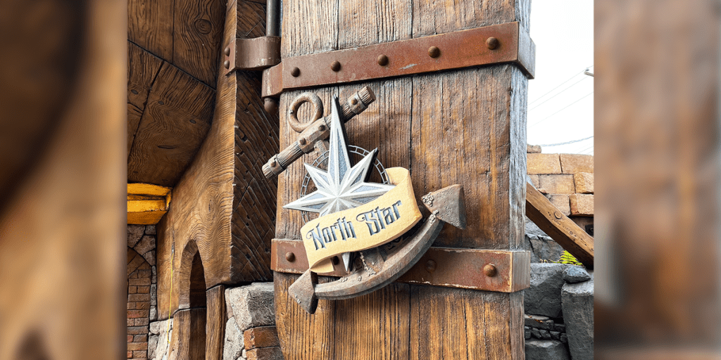 "North Star" sign with anchor and compass star motif on a weathered wooden building exterior