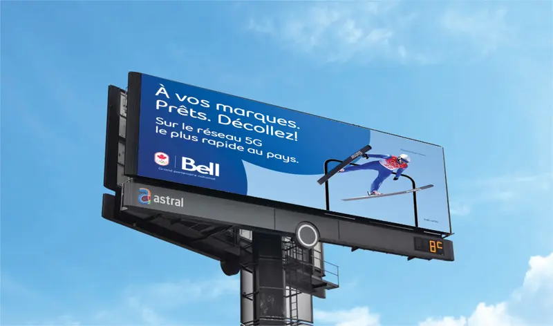 Billboard ad for Bell 5G network featuring a ski jumper in mid-air and French text about the country's fastest 5G service.