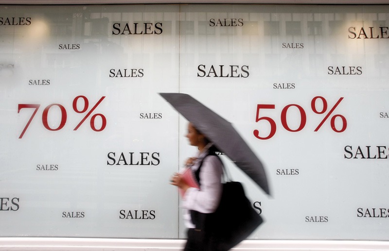 Person walks past a sales banner.