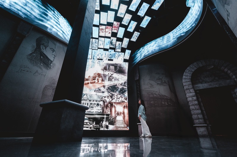 A visitor gazes up at a towering digital sign.
