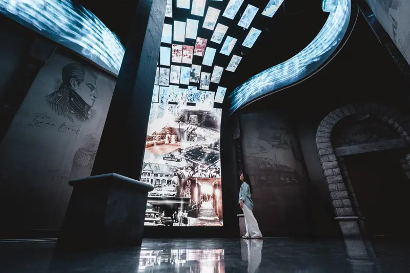 A visitor gazes up at a towering digital sign.