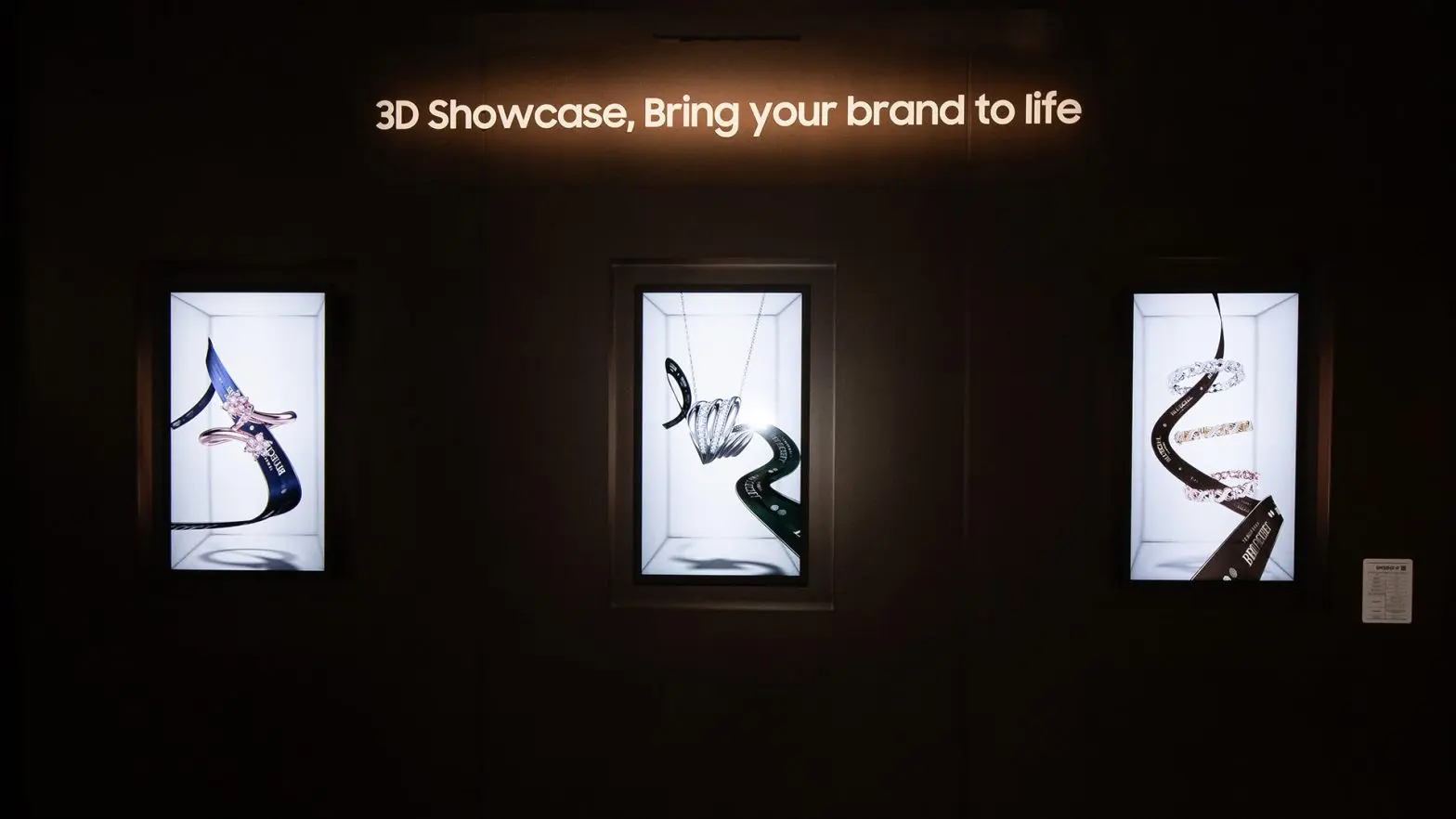 Three illuminated digital signage displays with 3D jewellery designs, under the text "3D Showcase, Bring your brand to life."
