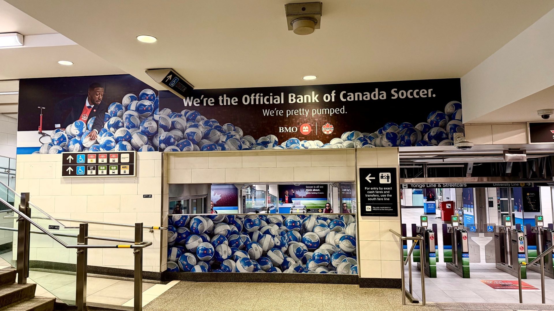 BMO Canada Soccer branded takeover of a Toronto subway station entrance, with soccer ball imagery and "We're the Official Bank of Canada Soccer" signage.