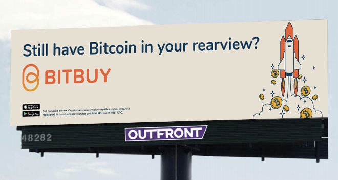 Billboard ad for Bitbuy crypto app reading 'Still have Bitcoin in your rearview?' with a rocket launching alongside Bitcoin coins, mounted above an OUTFRONT sign.
