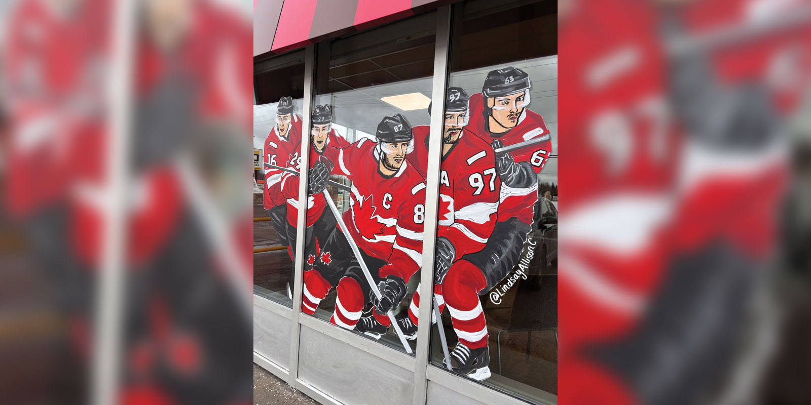Storefront windows feature painted illustrations of five Team Canada hockey players in red jerseys with sticks raised.