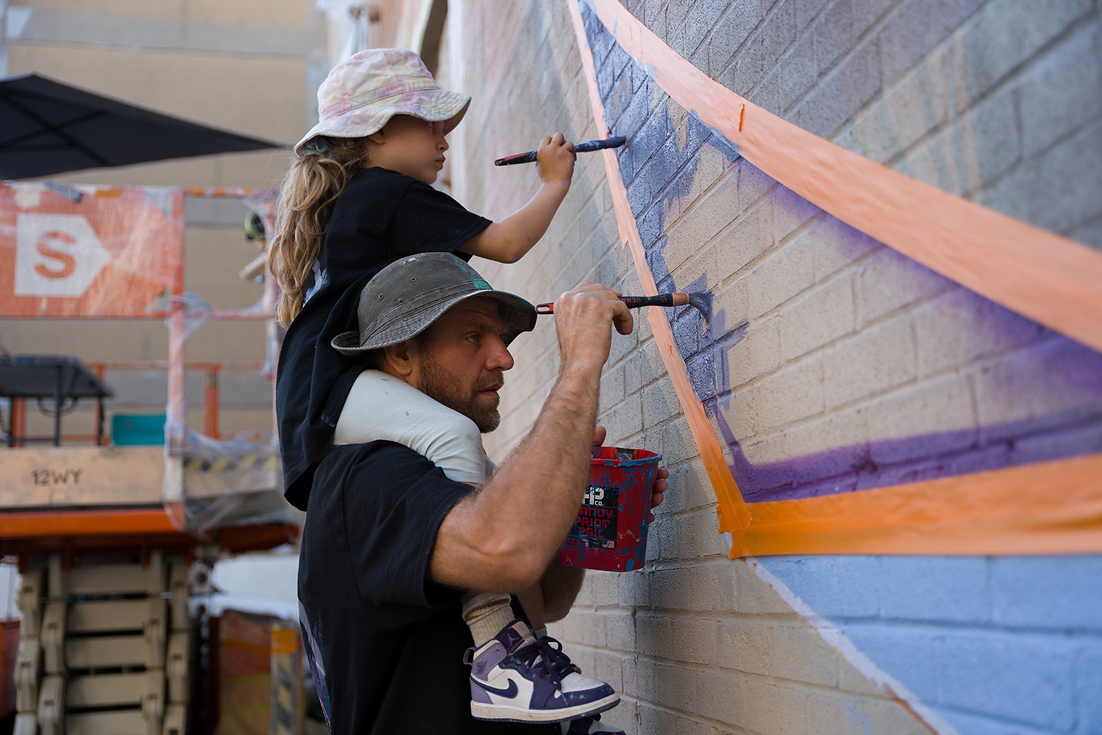 The father-daughter duo paint the mural.