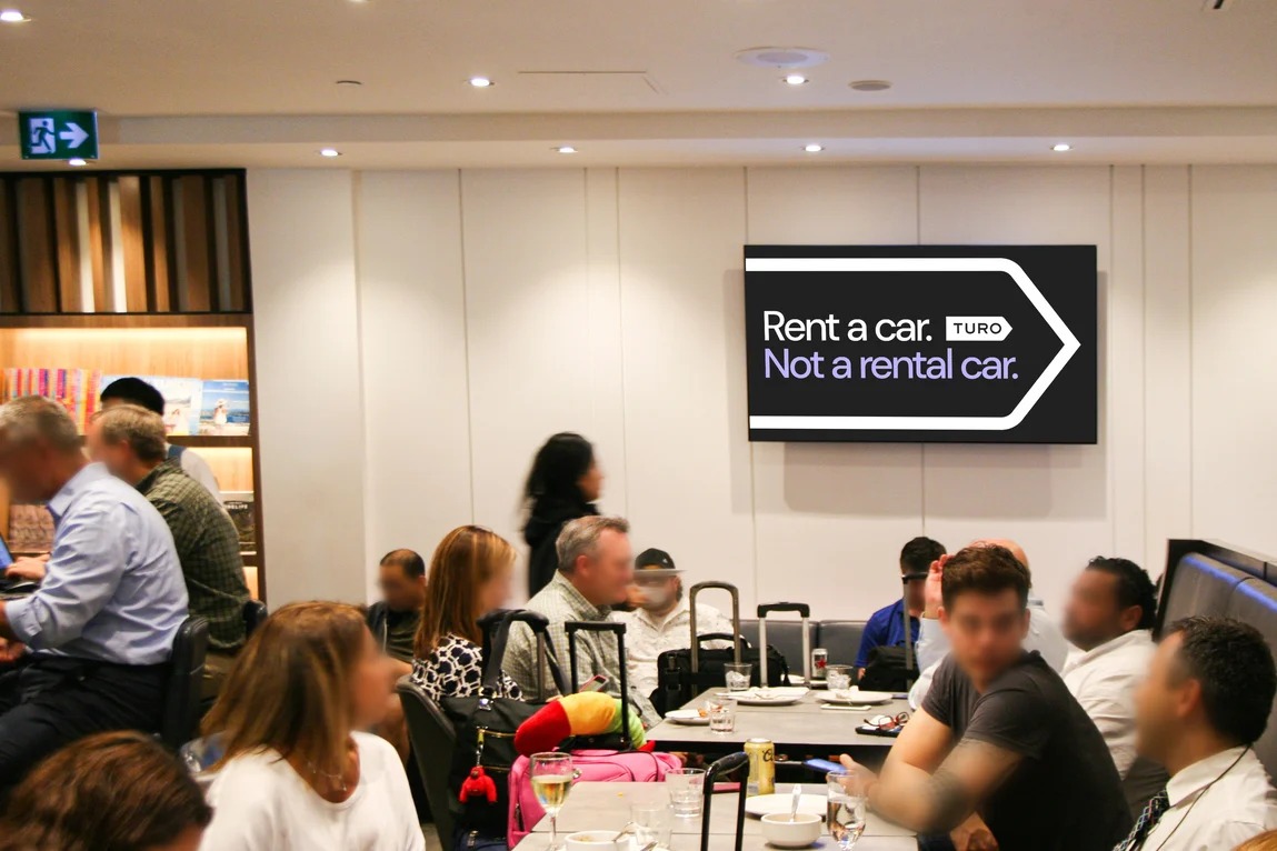 The ad on a digital screen in a busy airport lounge.